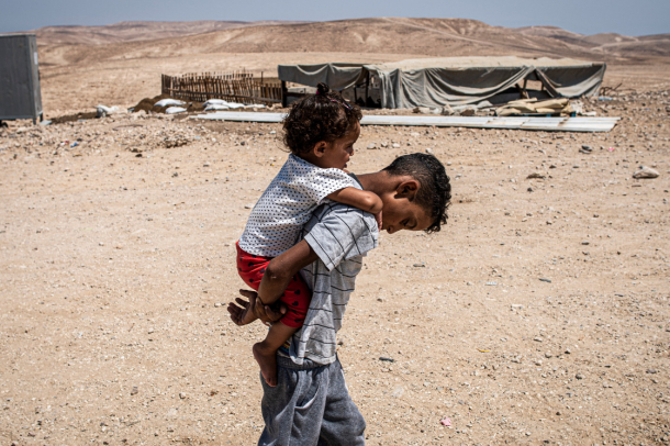 Egy beduin kisfiú épp húgát cipeli a hátán
Forrás: mti.hu
Szerző: Kallos Bea
